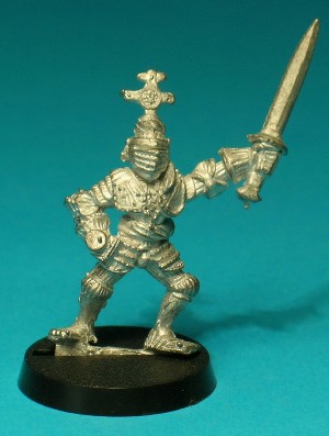 Pose 3. This character wears a full suit of plate armour, ornately decorated with ribbed patterns. He wears the visor down on his great helm, which is adorned with an imposing crucifix emblem on the top. He holds a longsword aloft in his left hand and his right hand has a stud for a plastic shield.